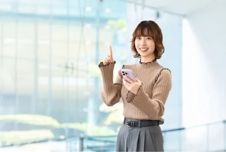 スマホを持って案内をする笑顔の女性
