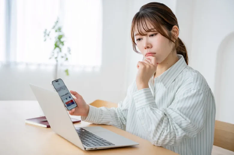 パソコンを眺めて悩む女性